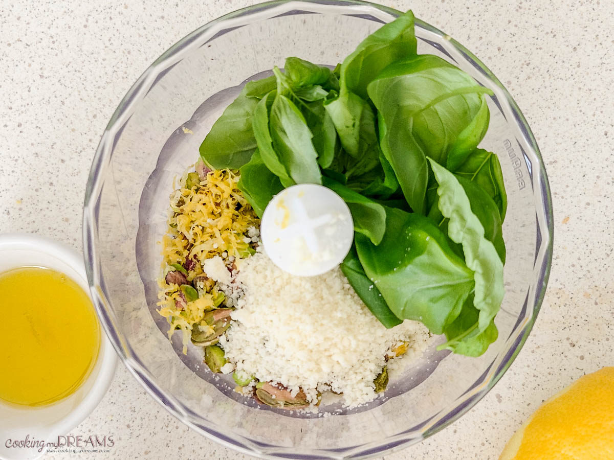 ingredients for pistachio pesto inside a food processor.