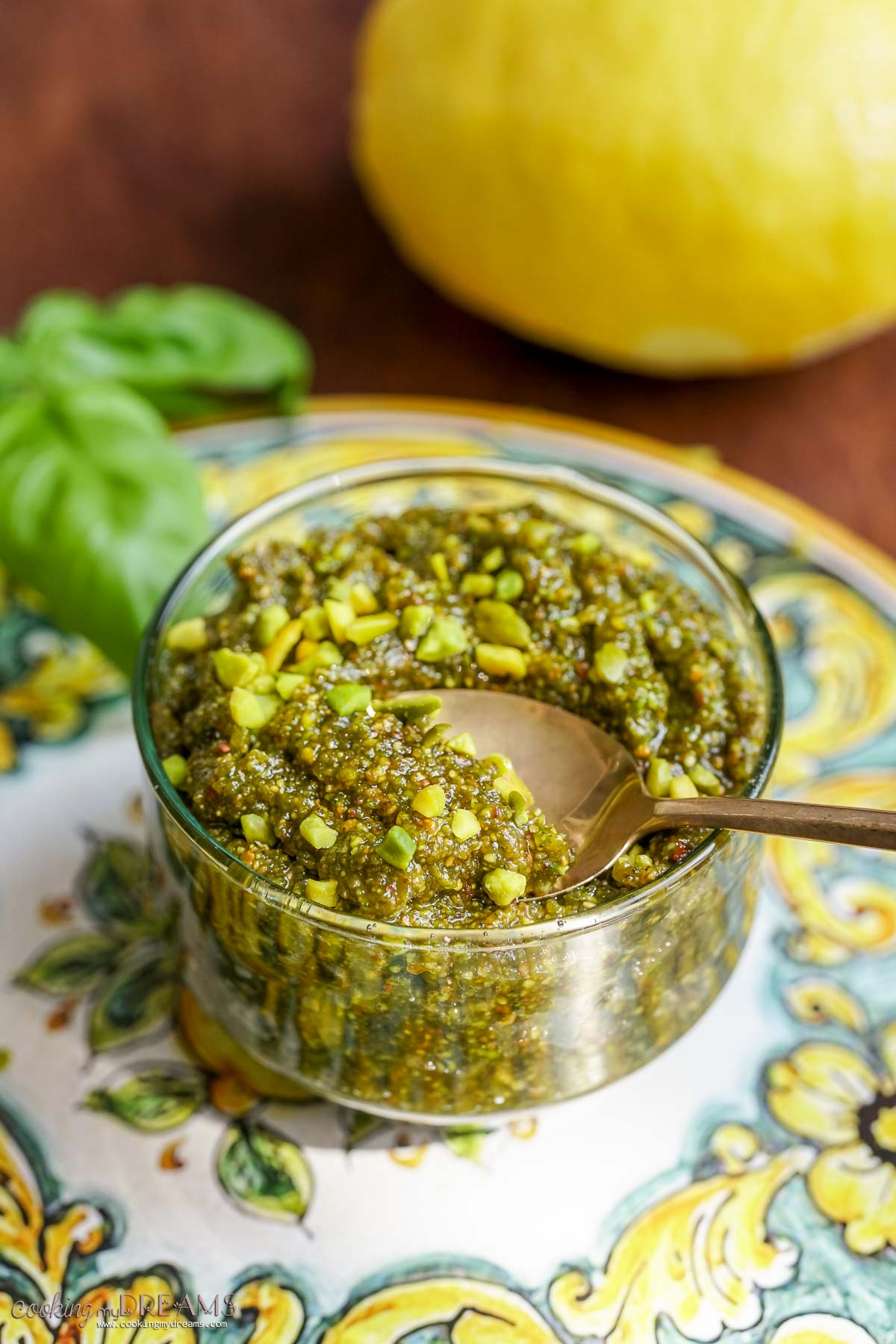 spoon scooping up some pistachio pesto from a glass jar.