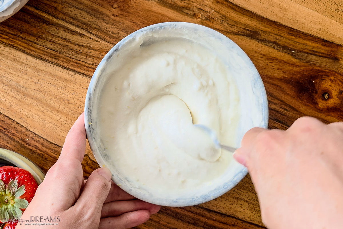 hands whipping ricotta in a bowl.