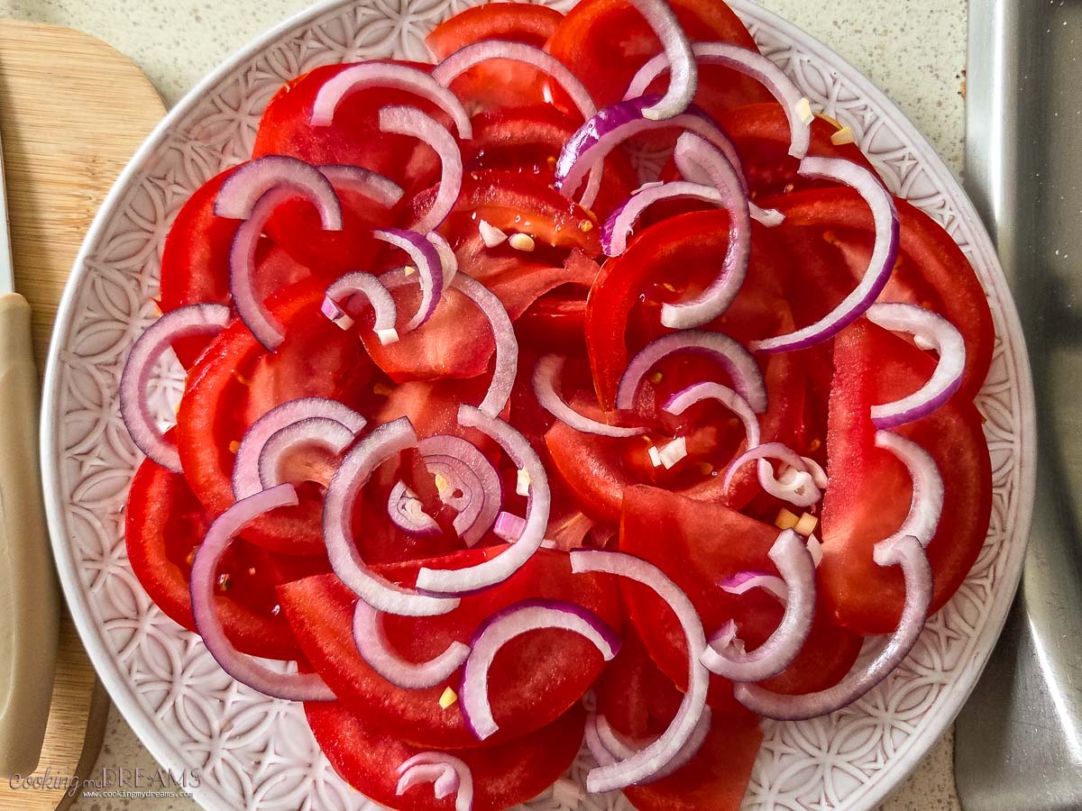 tomatoes and onions arranged on a plate.