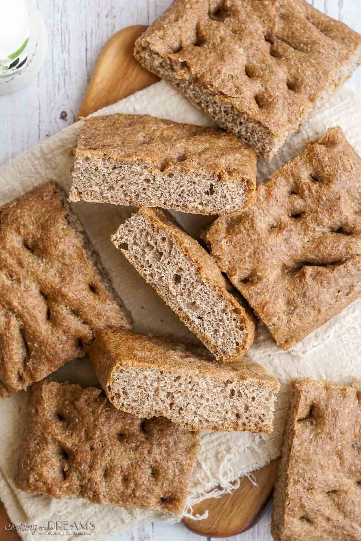 squares of whole wheat focaccia on a towel.