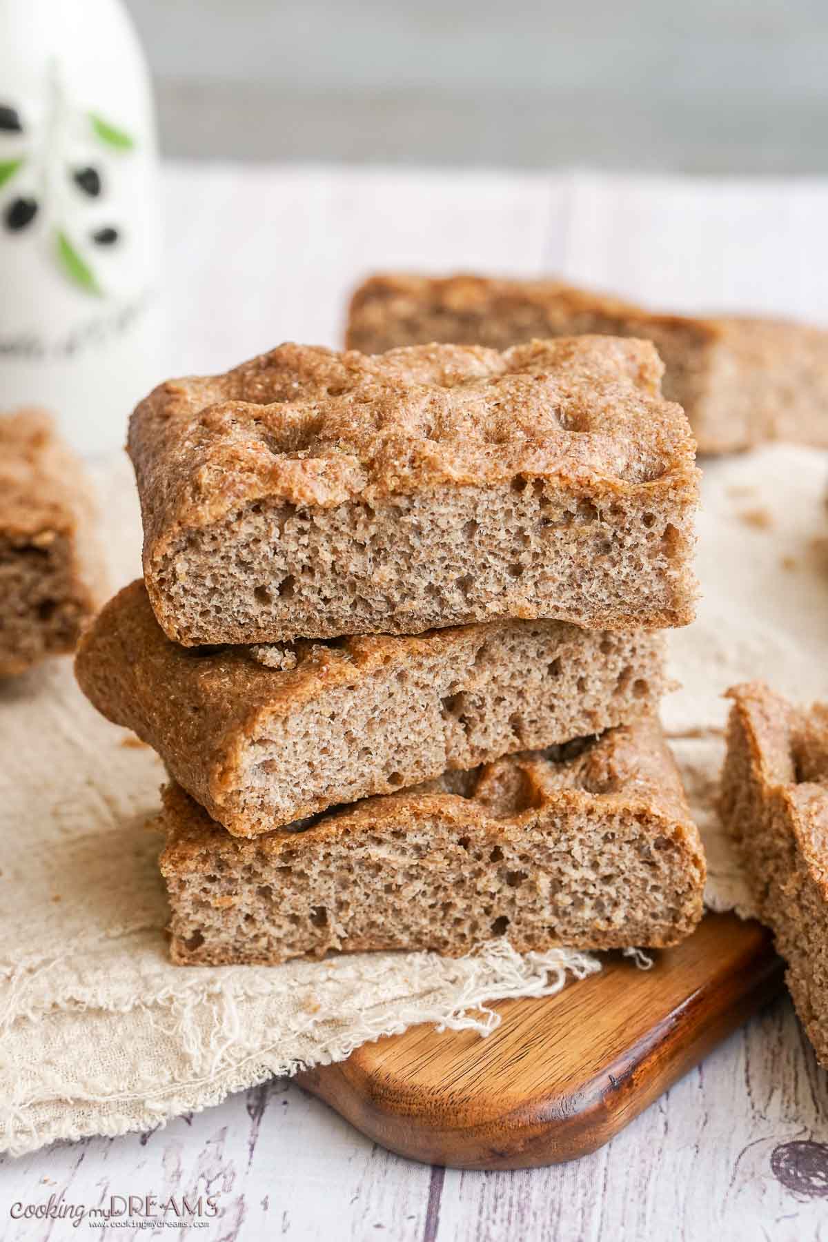 stack of squares of whole wheat focaccia on a towel.