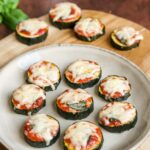 zucchini pizza bites on wooden board.