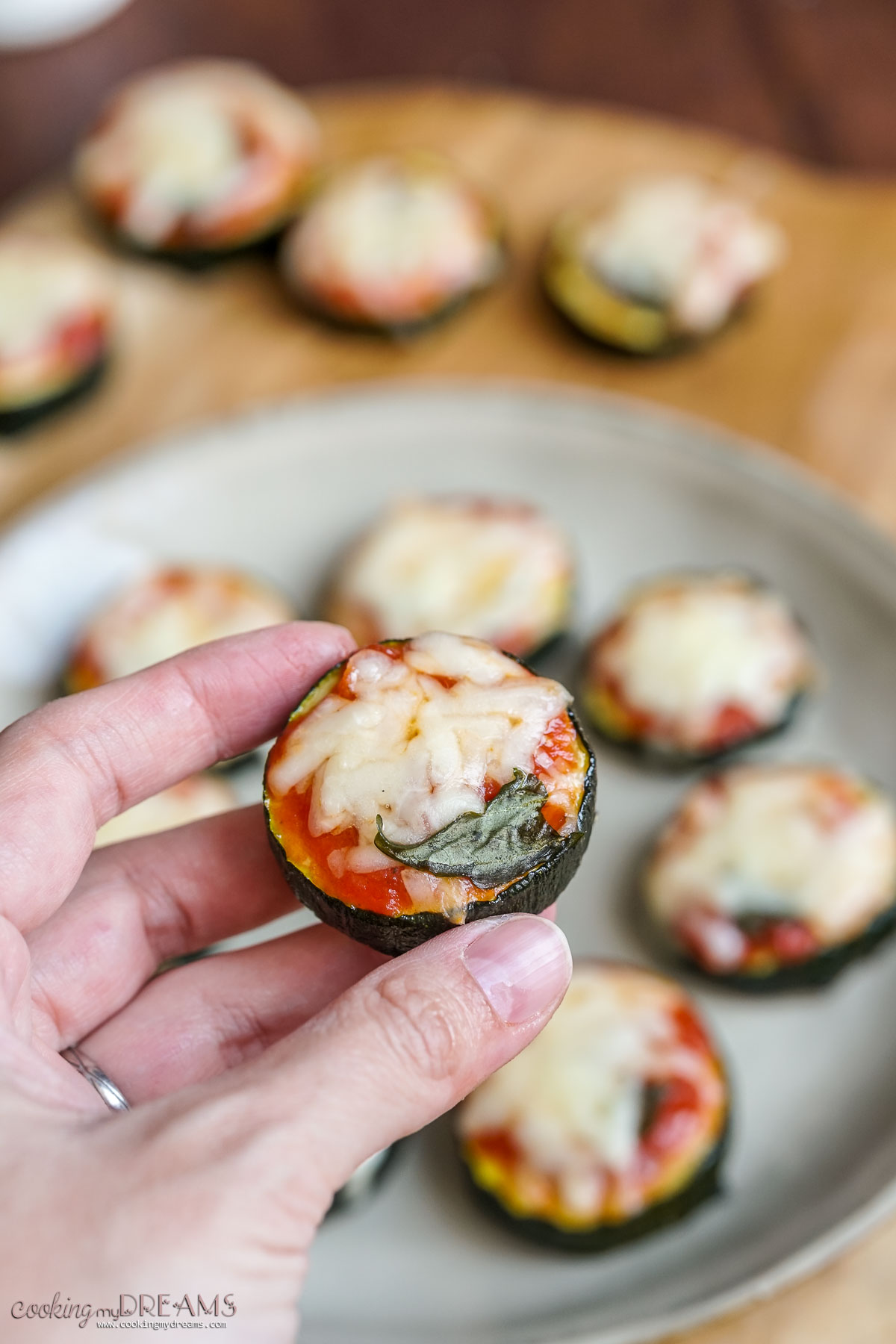 hand holding a zucchini pizza bite